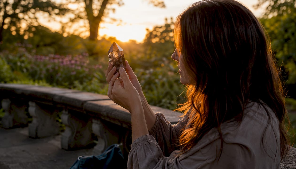 Person inspecting crystal markings outdoors in sunlight