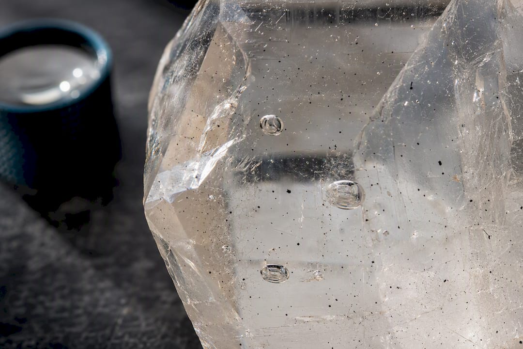Quartz crystal showing dark flecks and liquid pockets
