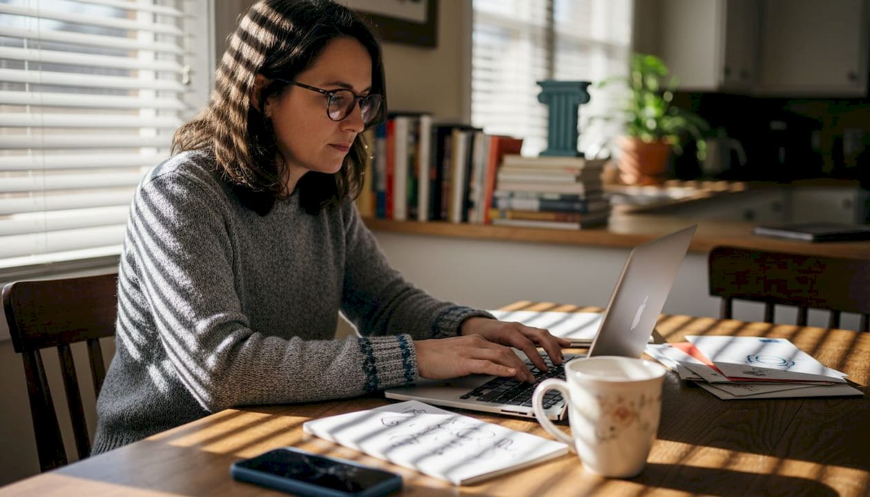 Remote worker using laptop in home kitchen