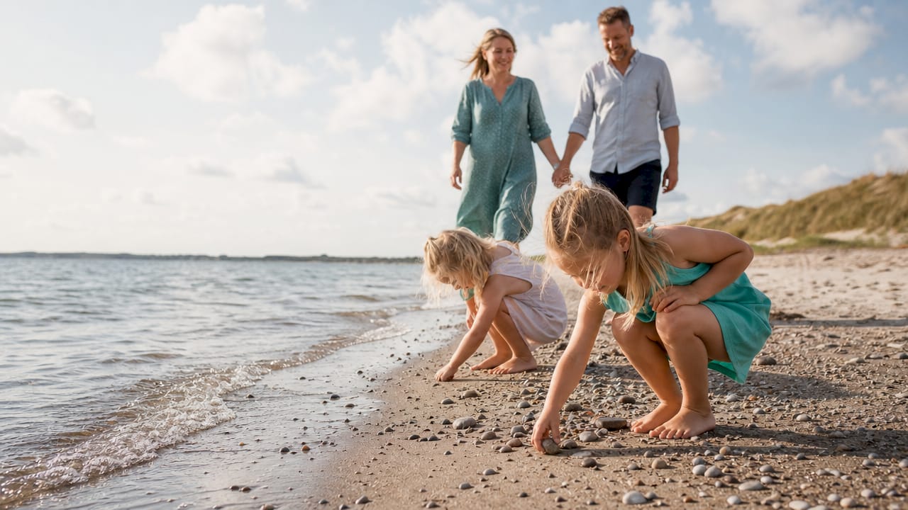Familien nyder en forårstur i det grønne ved søen og mellem træerne.