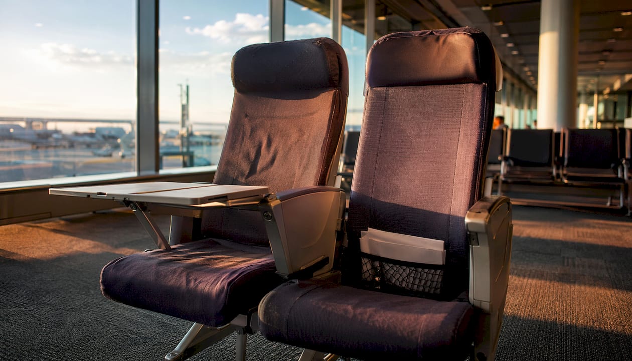 Sammenligning af sæderne i økonomiklasse og premium economy – side om side, så du tydeligt kan se forskellen på komfort og plads.