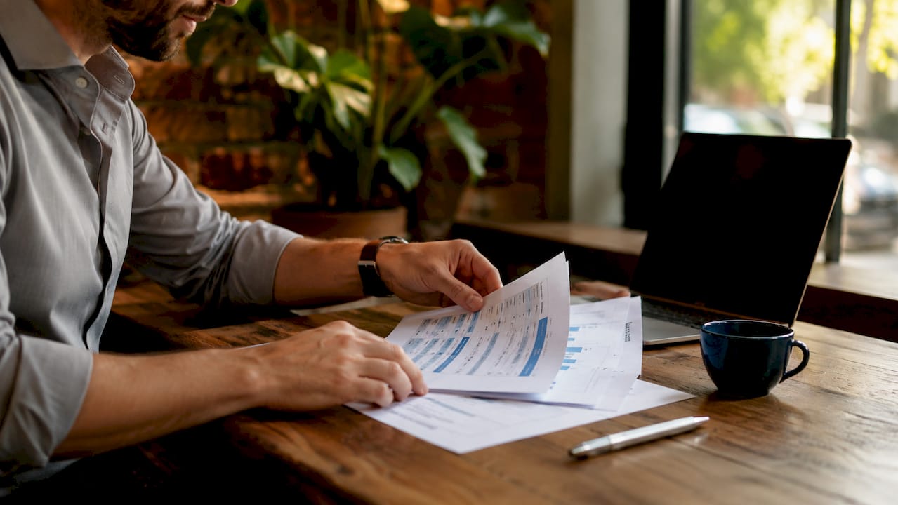 Hands reviewing competitor pricing comparison sheets