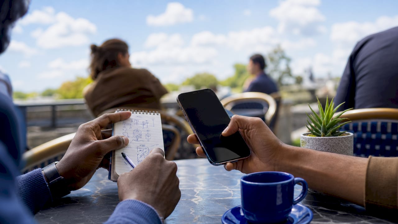 Hands coordinating calendar and smartphone for subscriptions