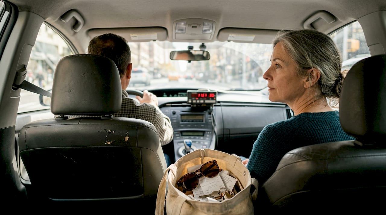 Una mujer viaja en taxi por Mallorca y se puede ver el taxímetro encendido.