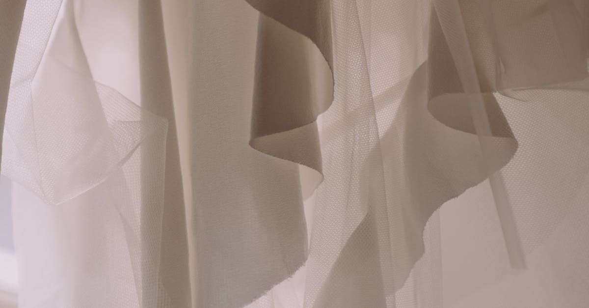 Designer and homeowner layering elegant sheer and textured curtains