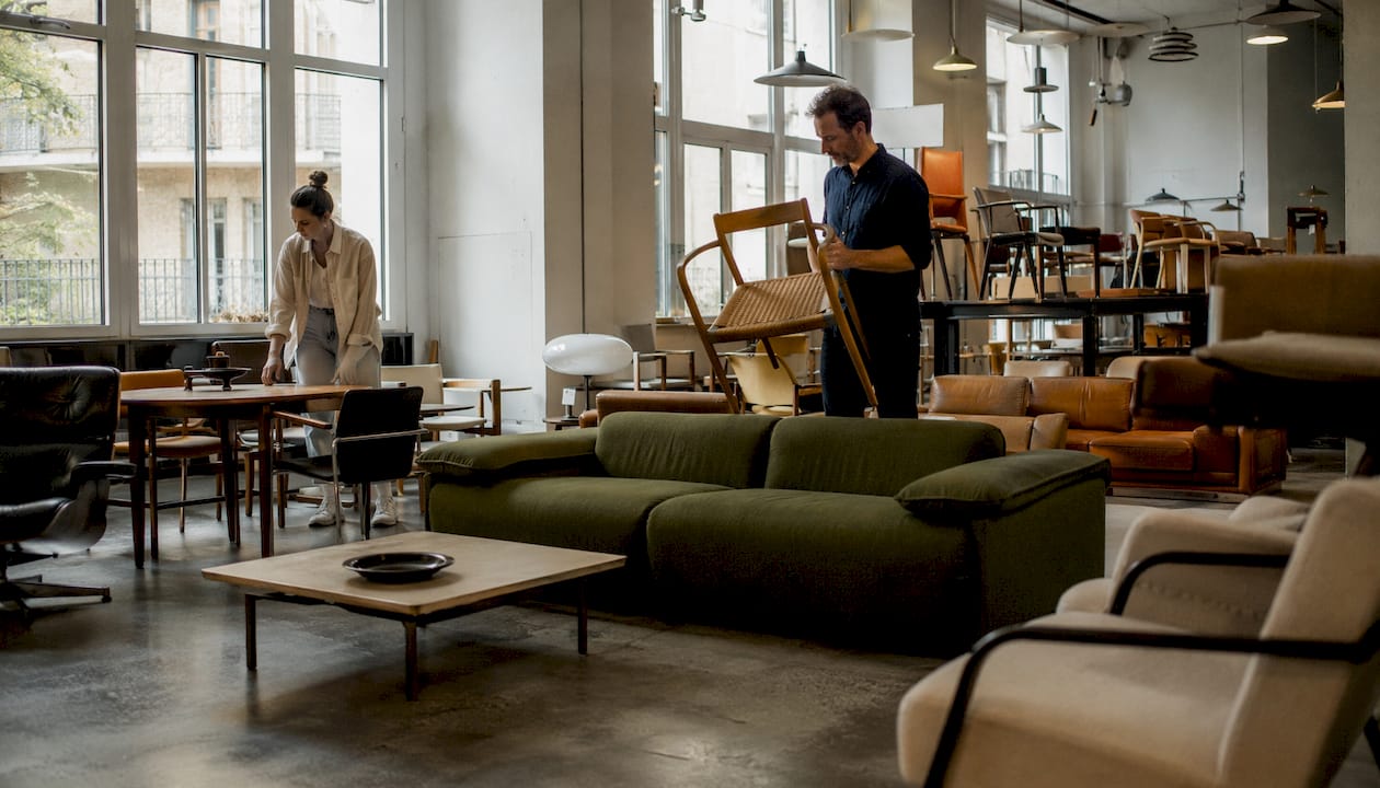 Una coppia curiosa passeggia tra arredi scenografici dal fascino vintage e dal design moderno esposti nello showroom, lasciandosi ispirare dalle diverse atmosfere.