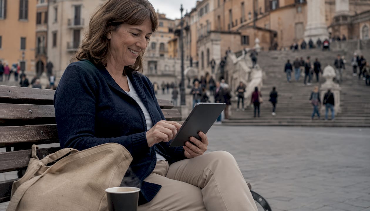 Una donna si gode un momento di relax leggendo materiali formativi al parco.