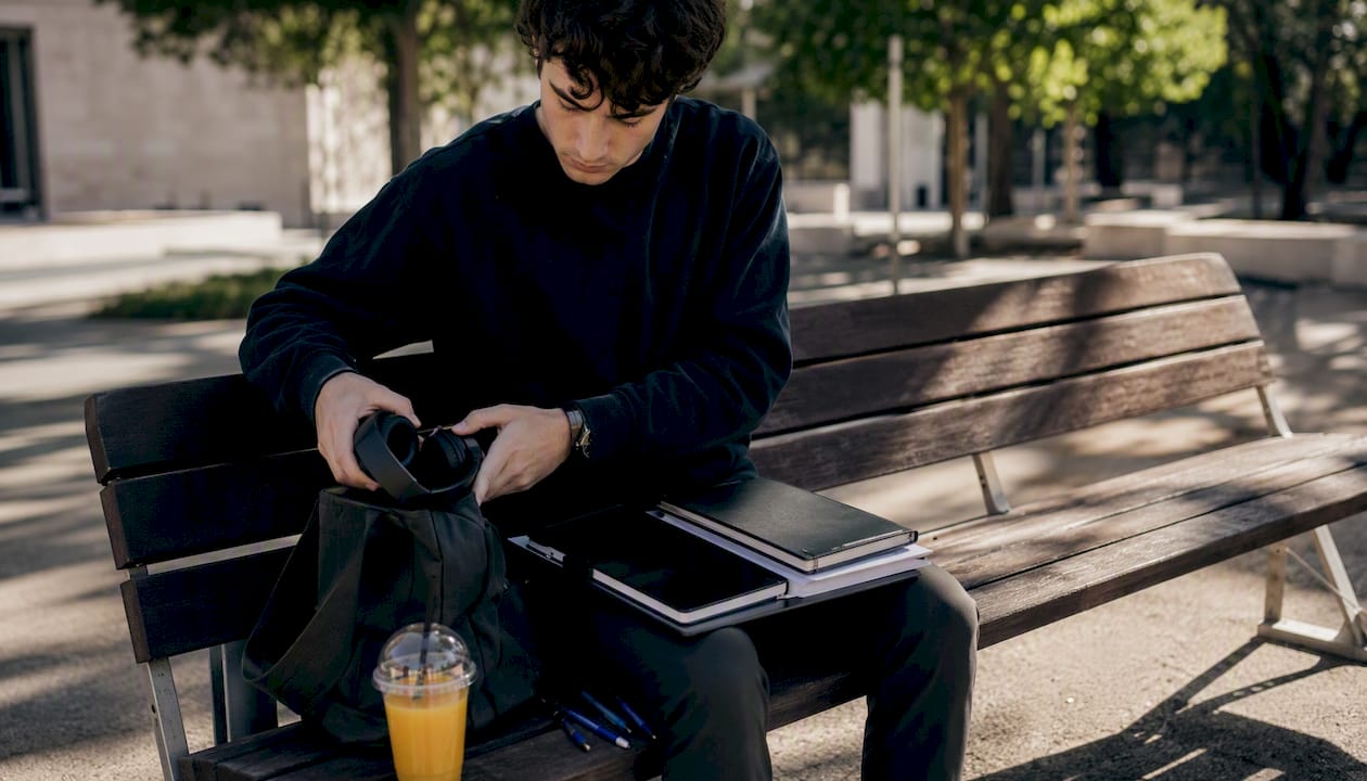 Uno studente che sistema il materiale per lo studio sulla scrivania di casa.
