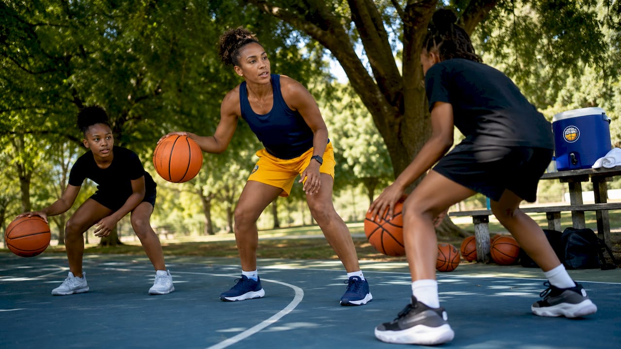 Assistant coach leading guard drill in gym practice
