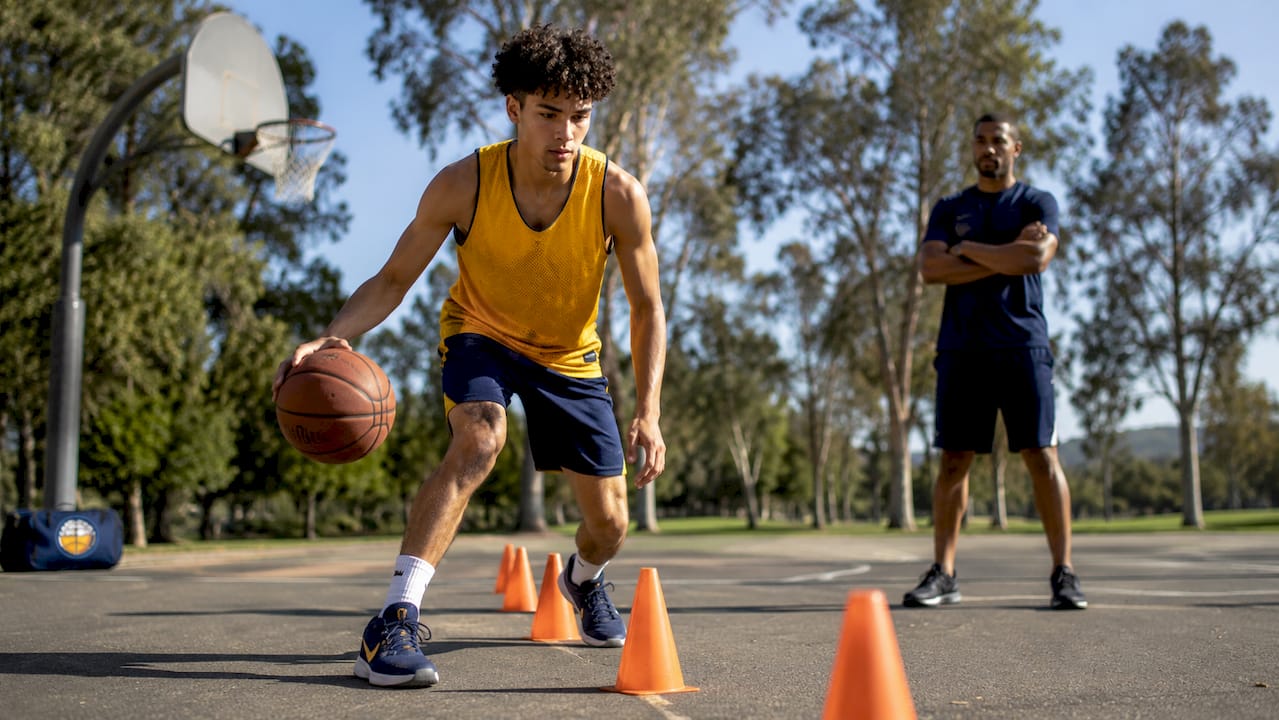 Basketball player performing ball-handling drill on court