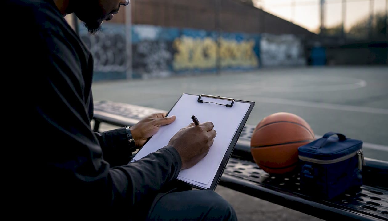 Coach writing philosophy notes clipboard