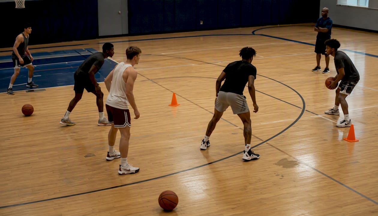 Players setting basketball offensive formation