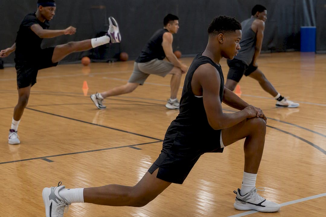 Players doing basketball warm-up drills in gym