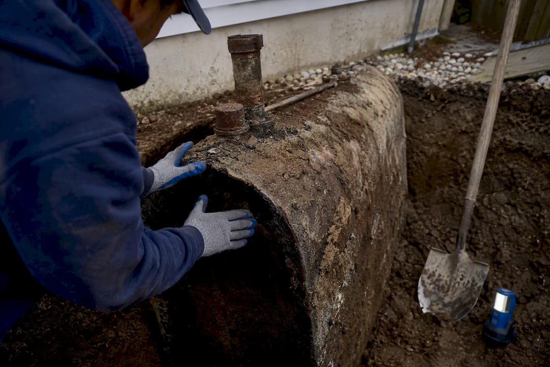 Contractor inspecting exposed residential oil tank