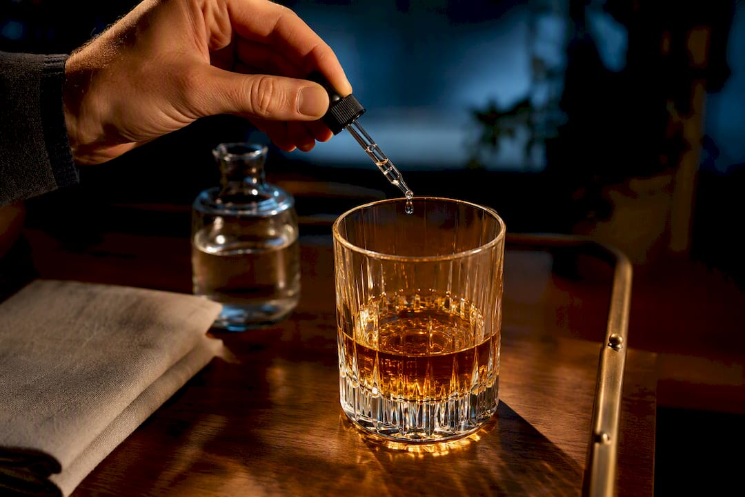 Water drops added to amber whisky