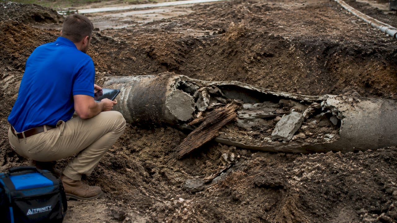 Close-up of damaged sewer pipe with construction debris