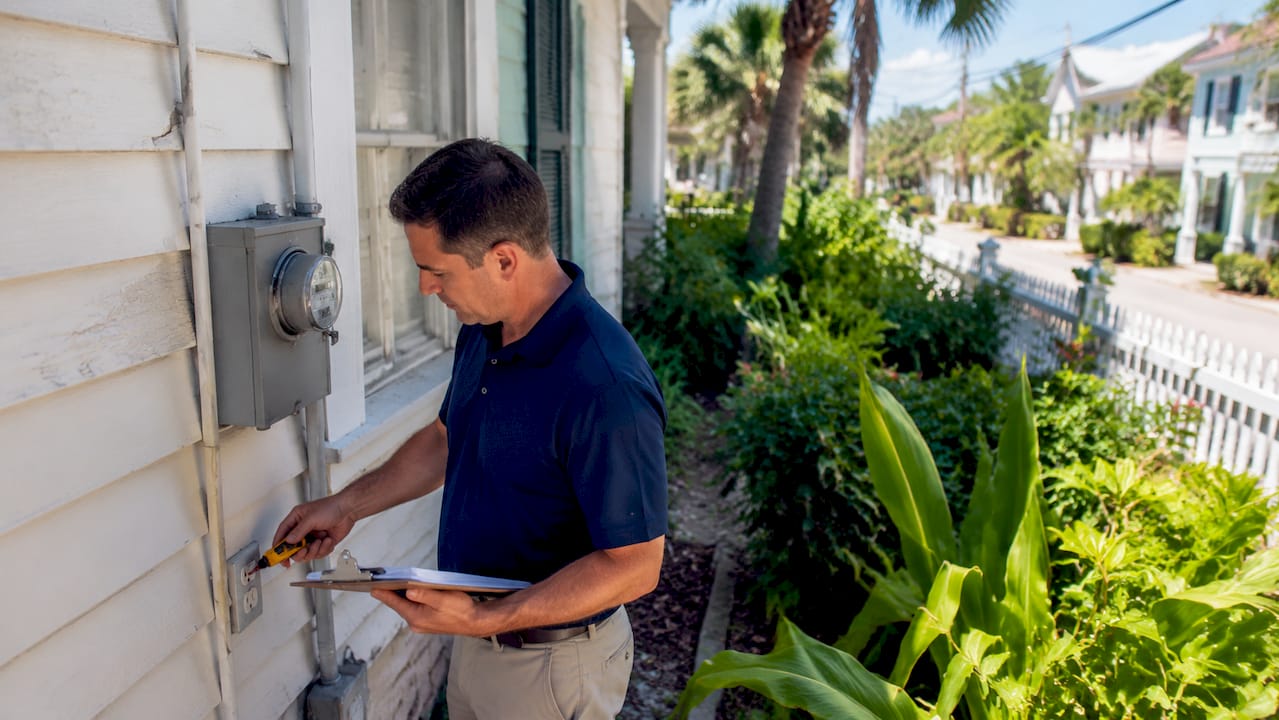 Home inspector checking outdoor GFCI outlet on Gulf Coast home