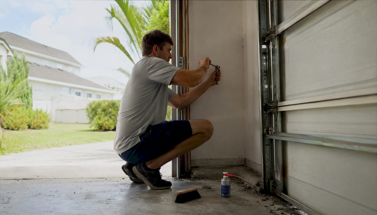 Inspector tightening garage door hardware