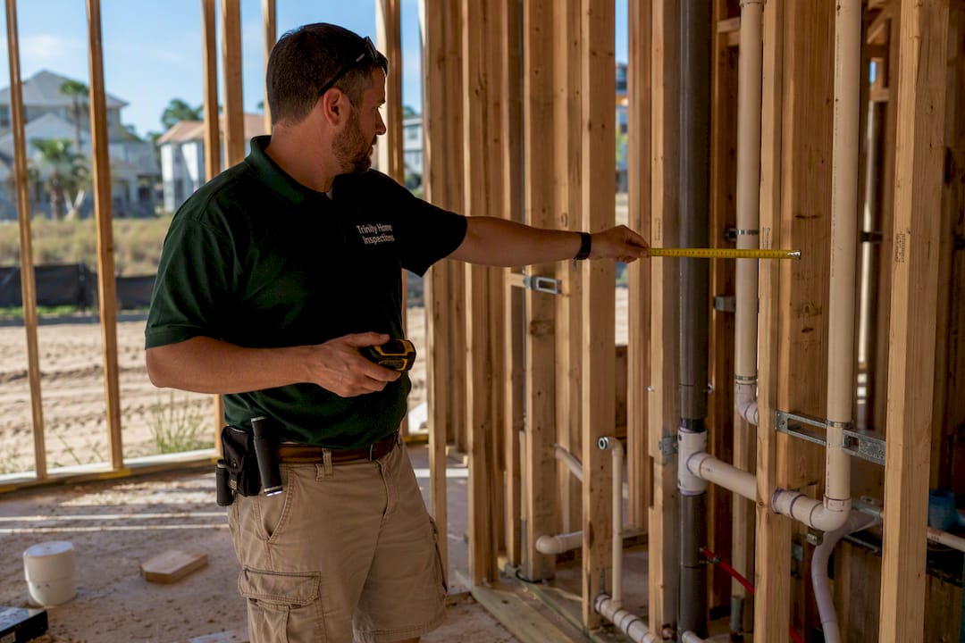 Home inspector examining new home framing