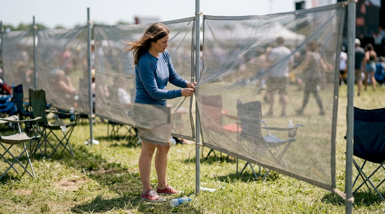 Coordinator adjusts mesh banner at outdoor event