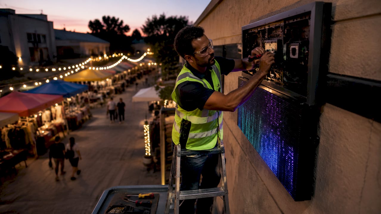 Technician installing digital storefront sign