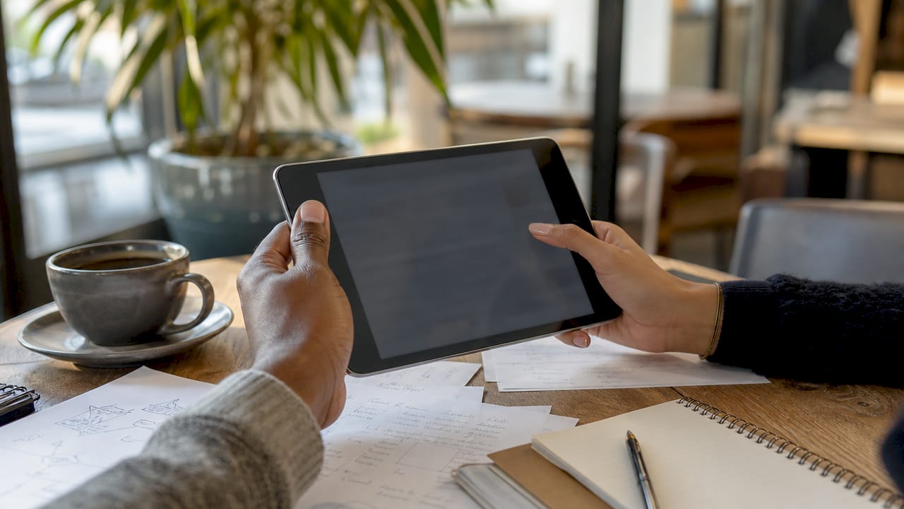 Hands auditing citations on tablet in workspace