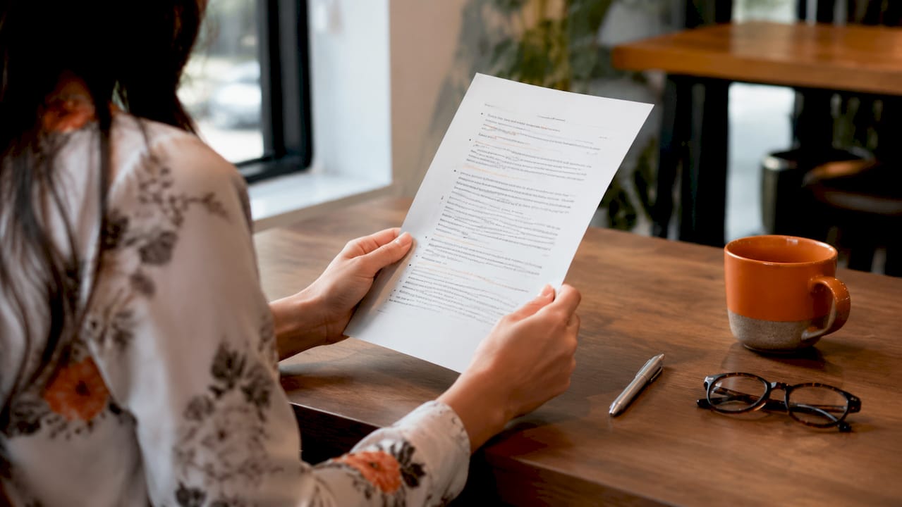 Hands holding password security guideline document in office
