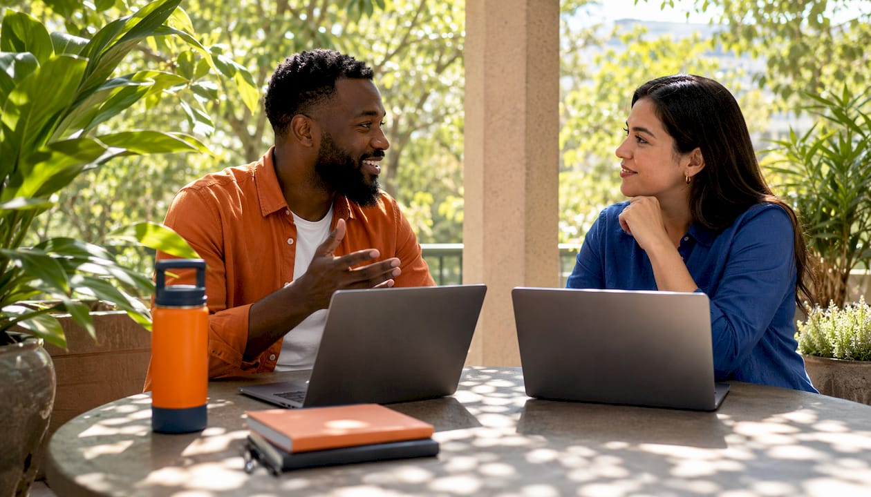Coworkers discussing password security near laptops