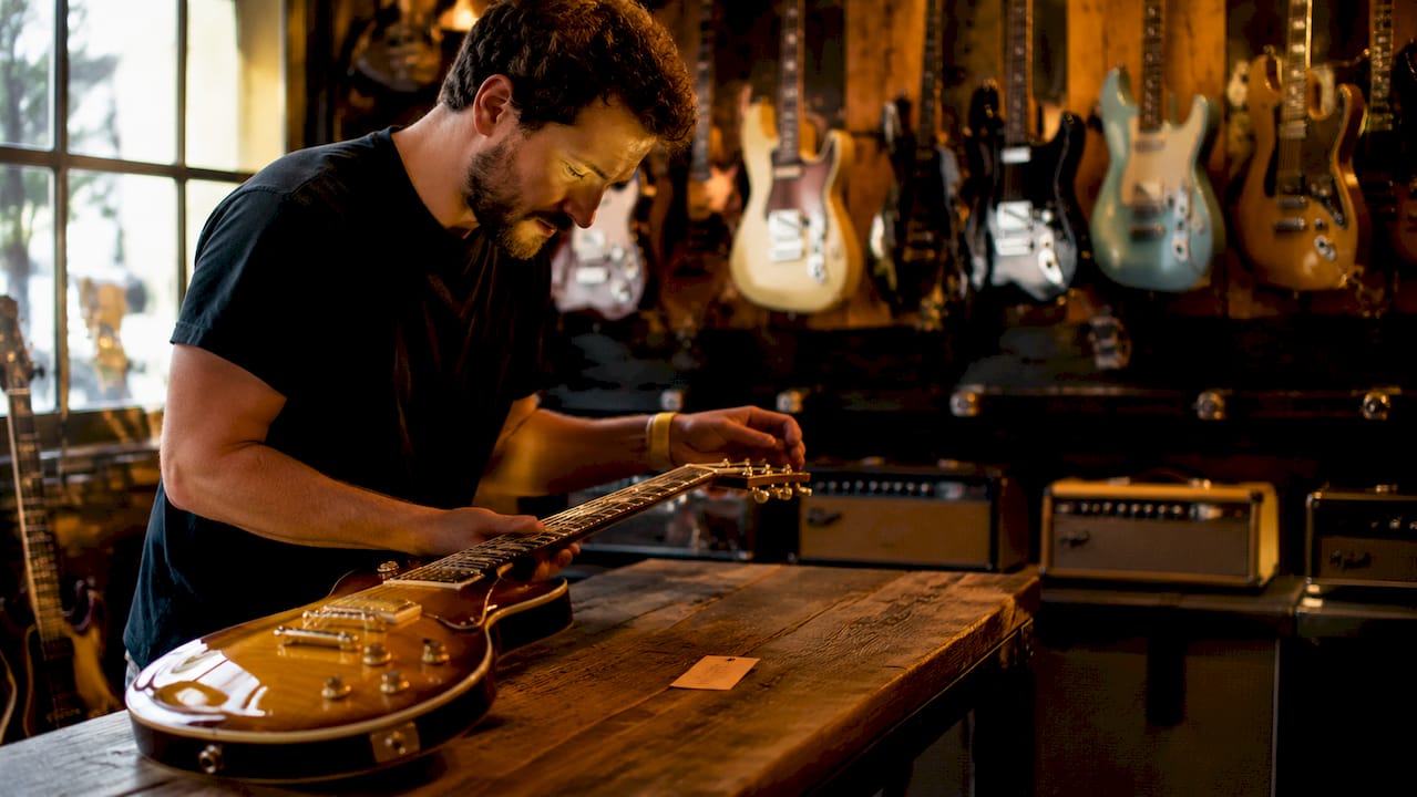 Hands inspecting electric guitar in store