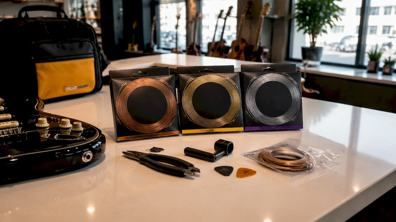 Various acoustic guitar string sets on wood table