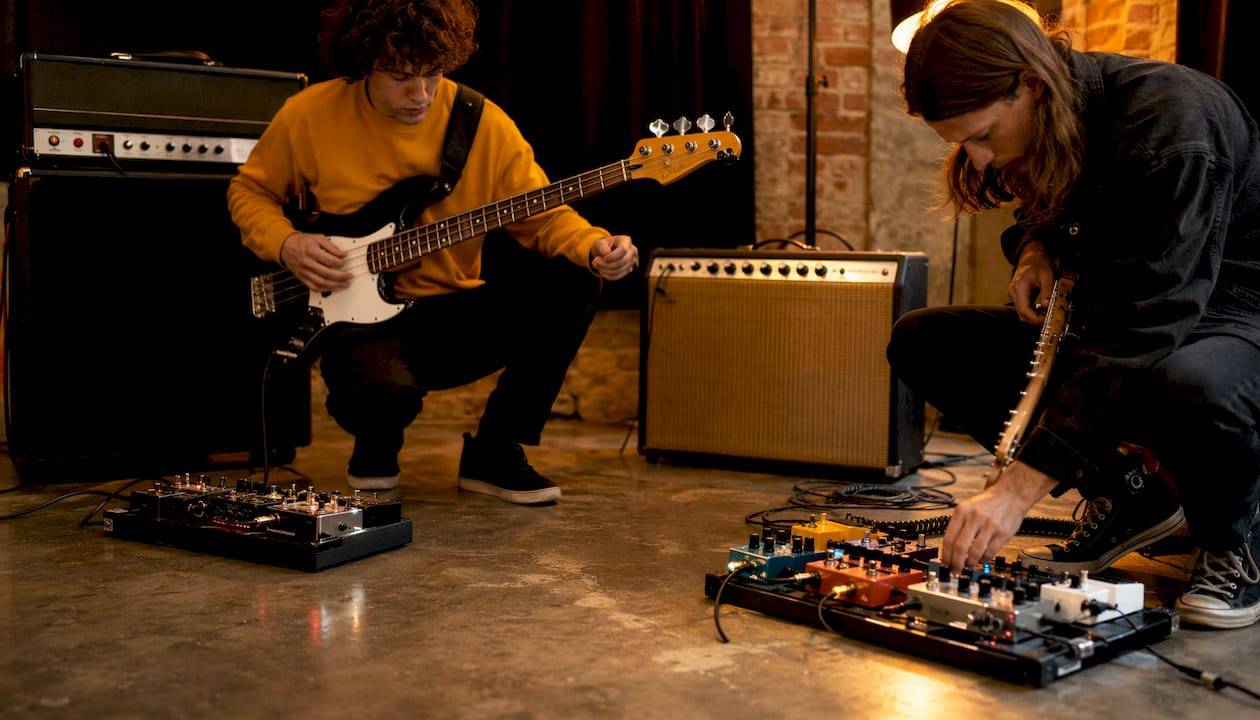 Hands adjusting bass and guitar sound equipment