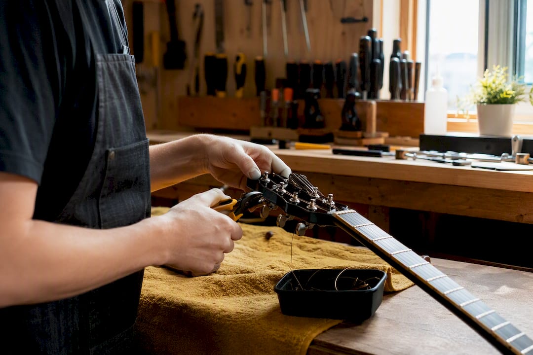 Hands cutting old guitar strings carefully