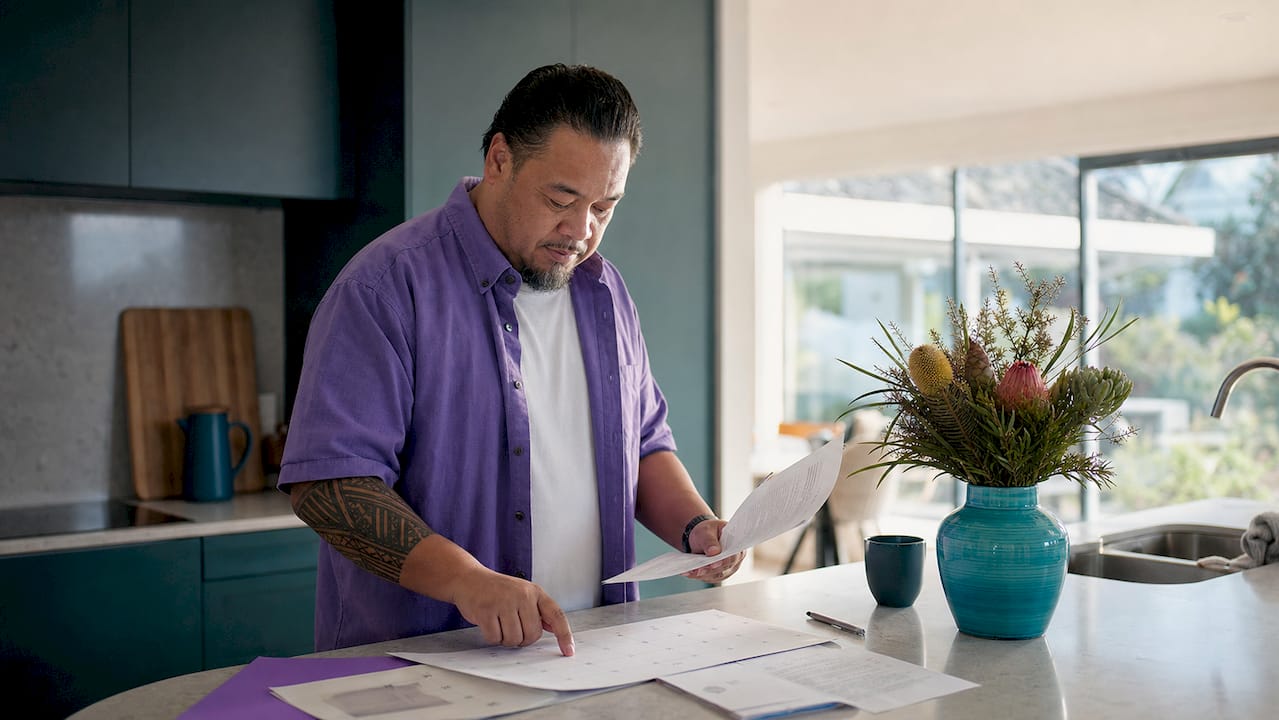 Hands sorting tenancy notice documents in NZ home