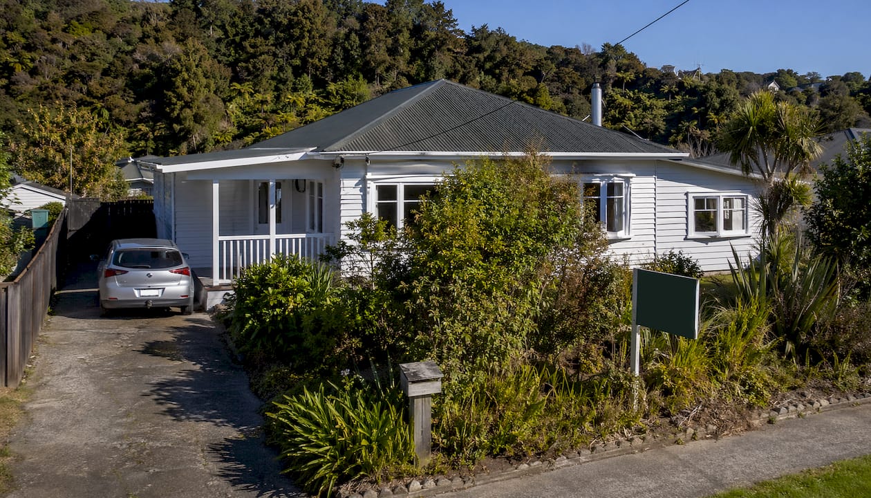 Typical NZ house with investor offer sign