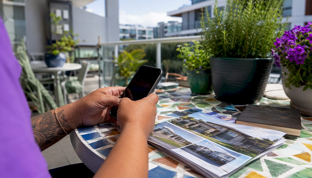 Hands using phone and brochures for private sale