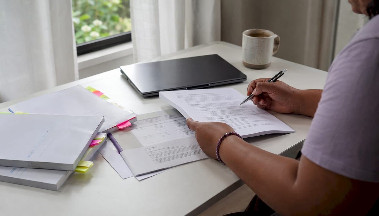 Hands reviewing tenancy law documents at desk