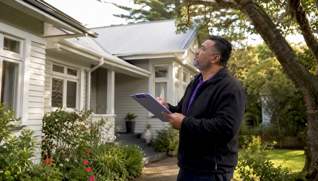 Man inspecting NZ house compliance outside