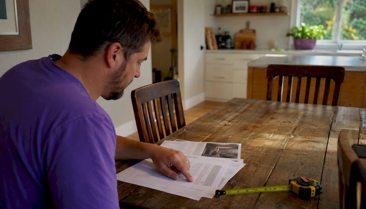 Closer hands reviewing NZ home repair estimates