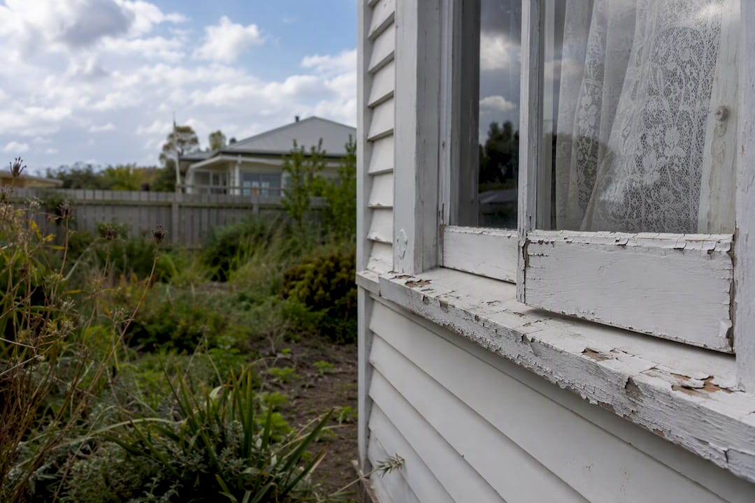Peeling paint and cracked window on NZ house