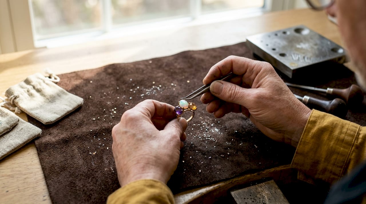 Hands pairing opal with amethyst and citrine