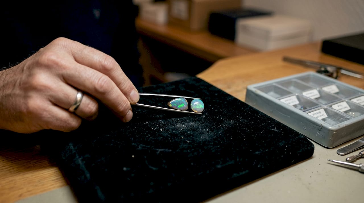 Nebeneinander auf edlem Samt präsentiert: ein echter Opal und ein Doublet.