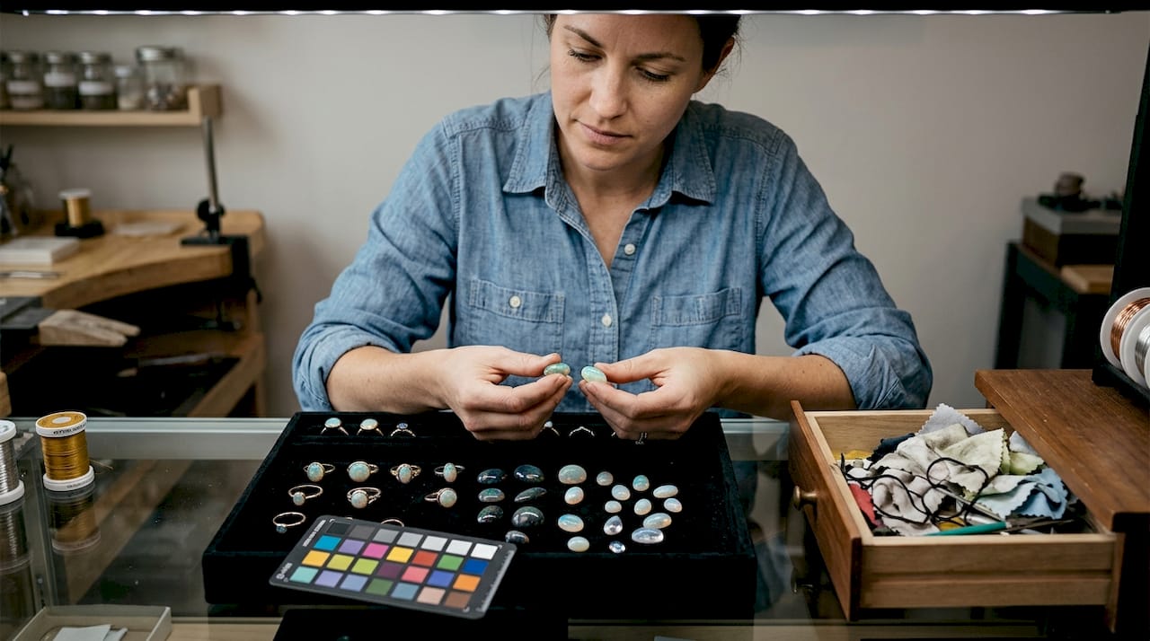 Jewelry designer arranging varied tone opals