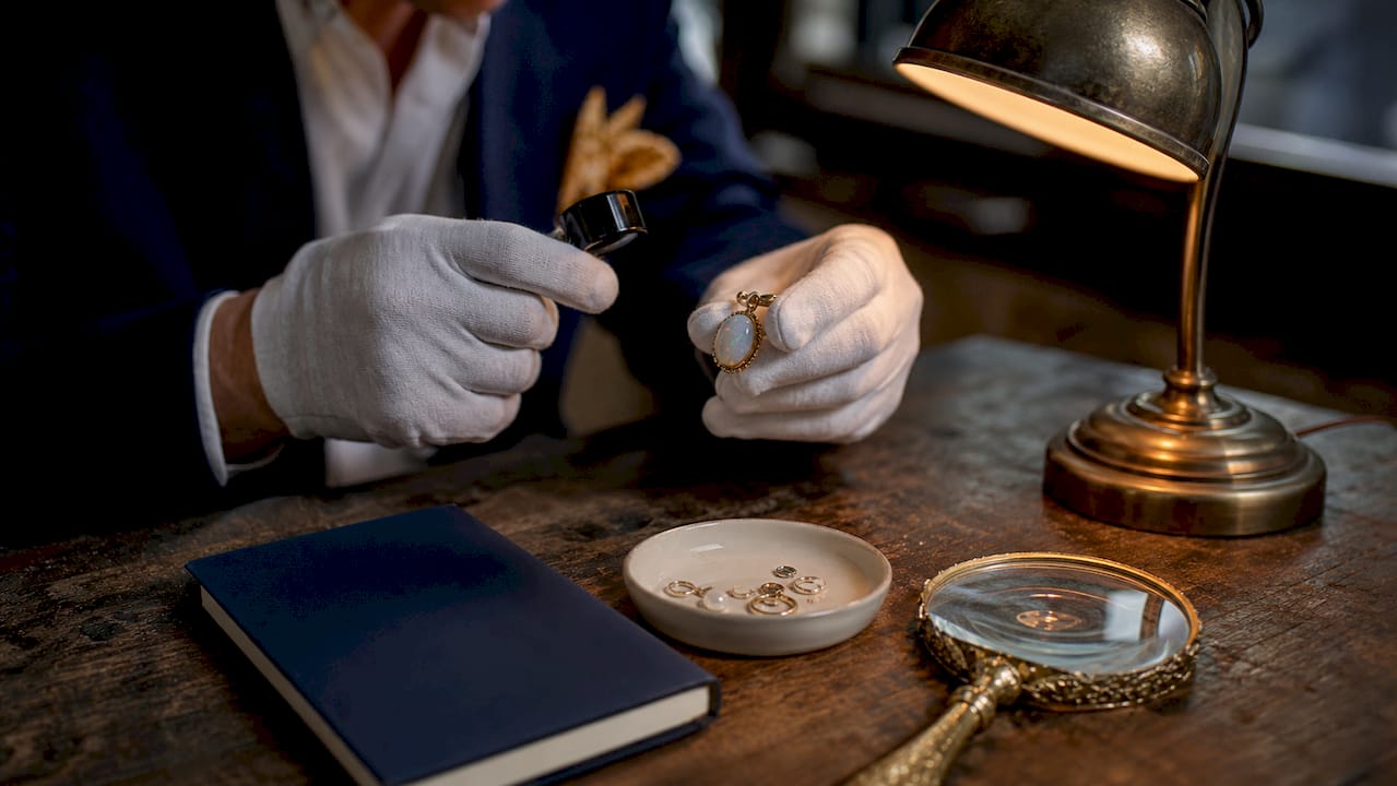 Jeweler inspecting opal pendant with tools