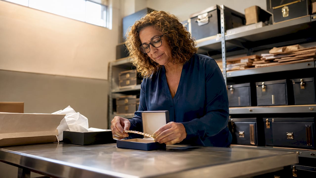 Une femme prend en photo un coffret à bijoux précieux avant de l’expédier.