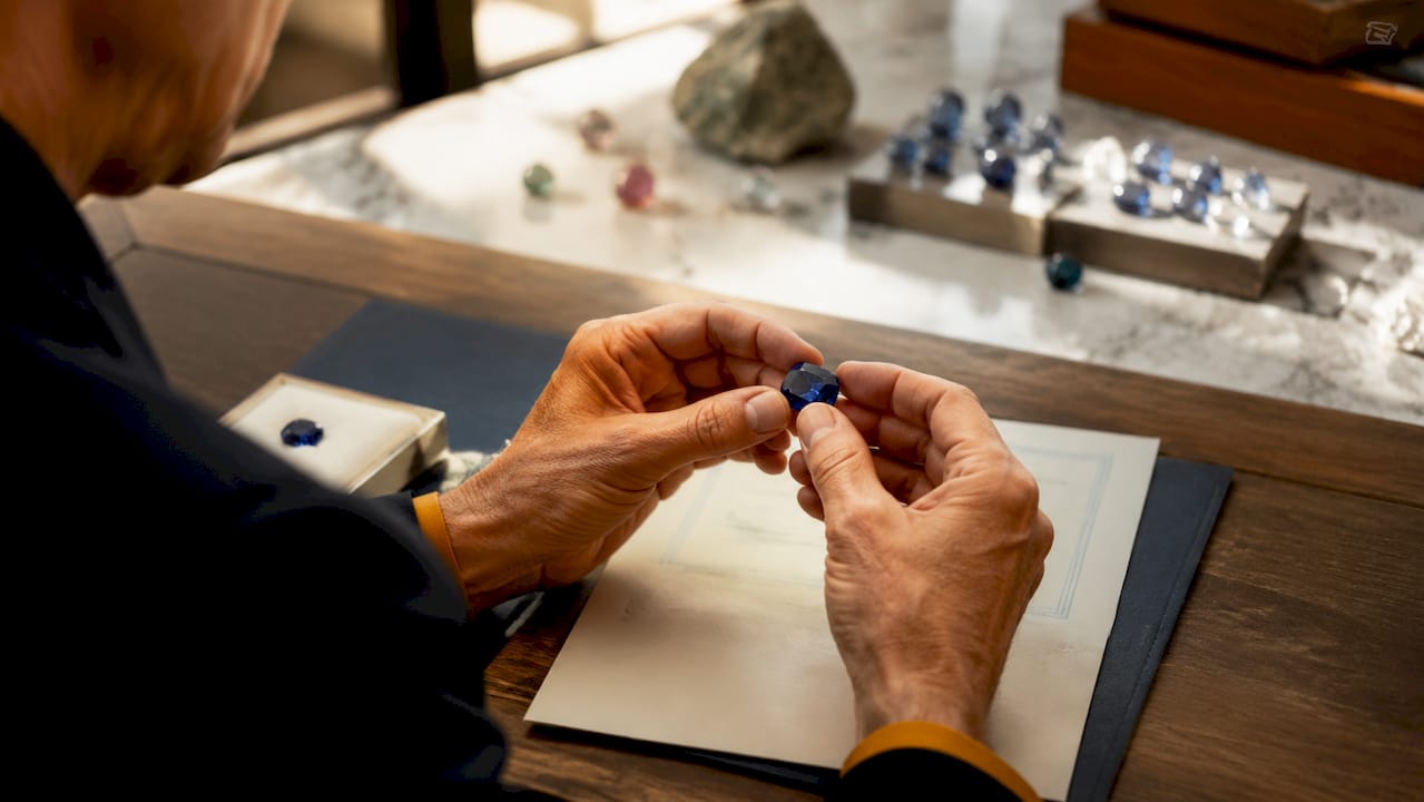 Hands holding sapphire with provenance documents