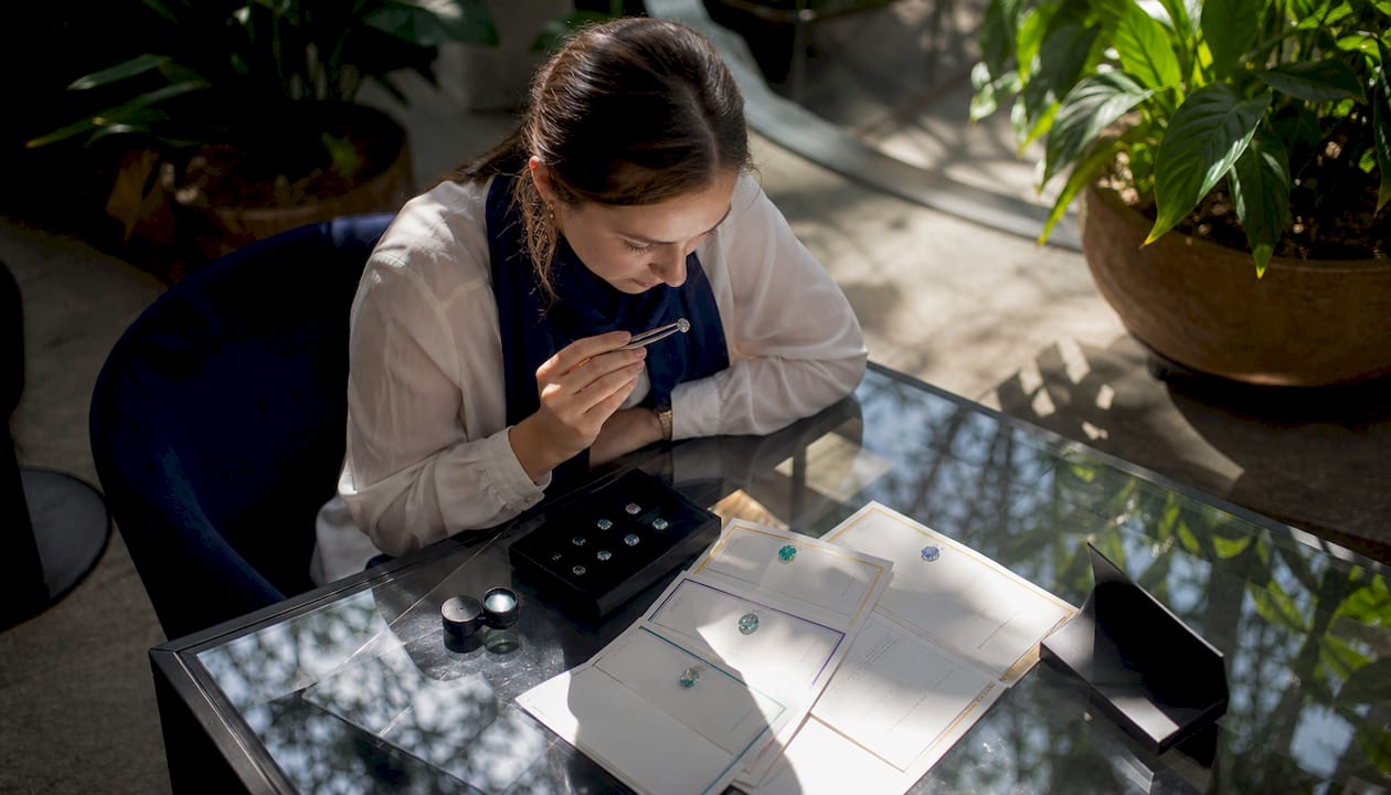 Buyer inspecting gemstone in office by window