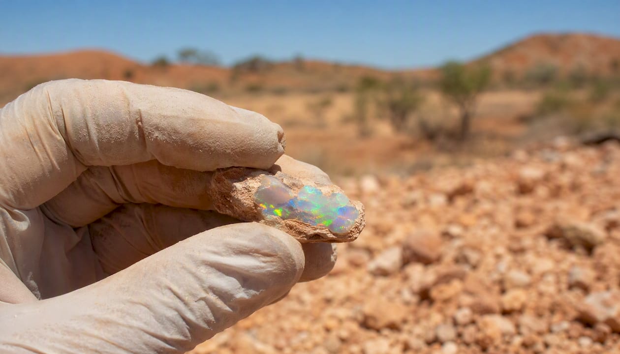Hand holding rough Coober Pedy opal specimen