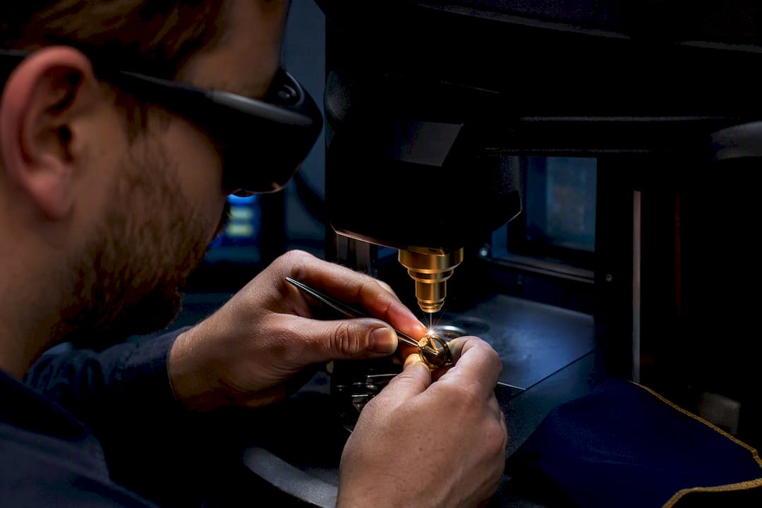 Jeweler laser welding an opal ring shank