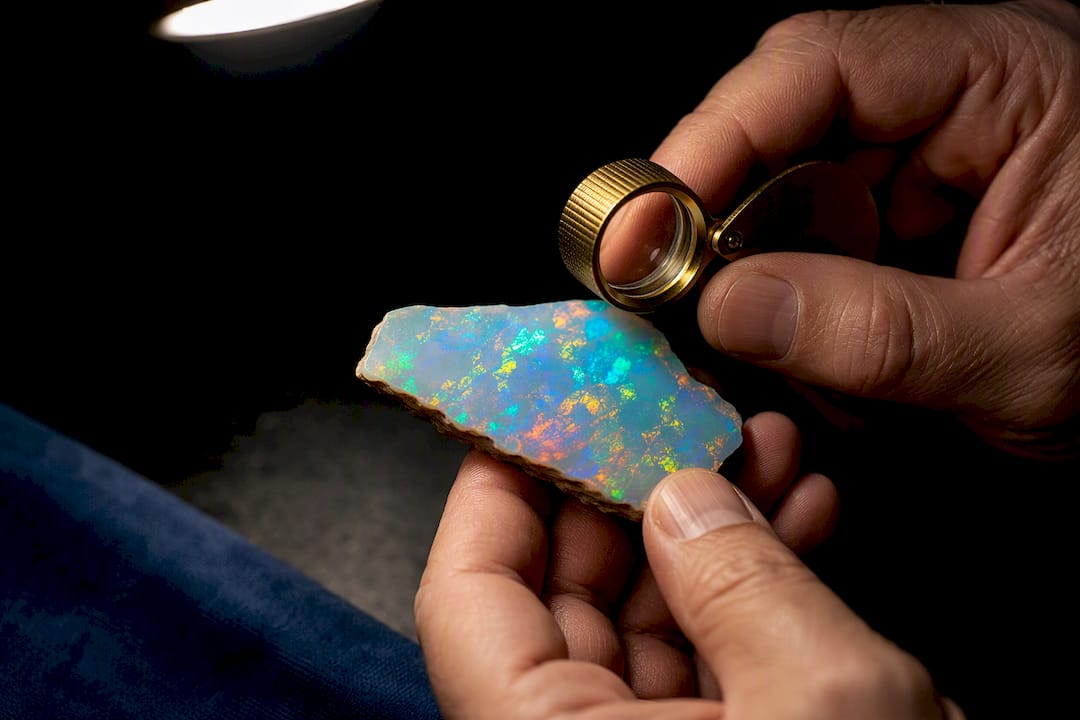 Buyer examining a loose opal fragment