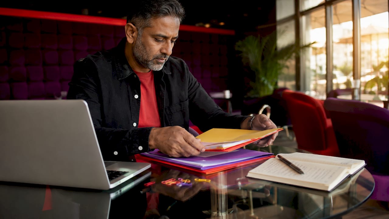 Hands organizing asset folders on desk